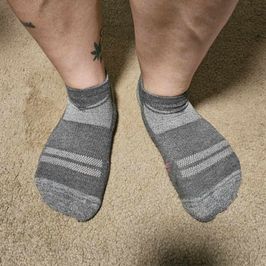 Light and dark grey socks with pink stripes on bottom