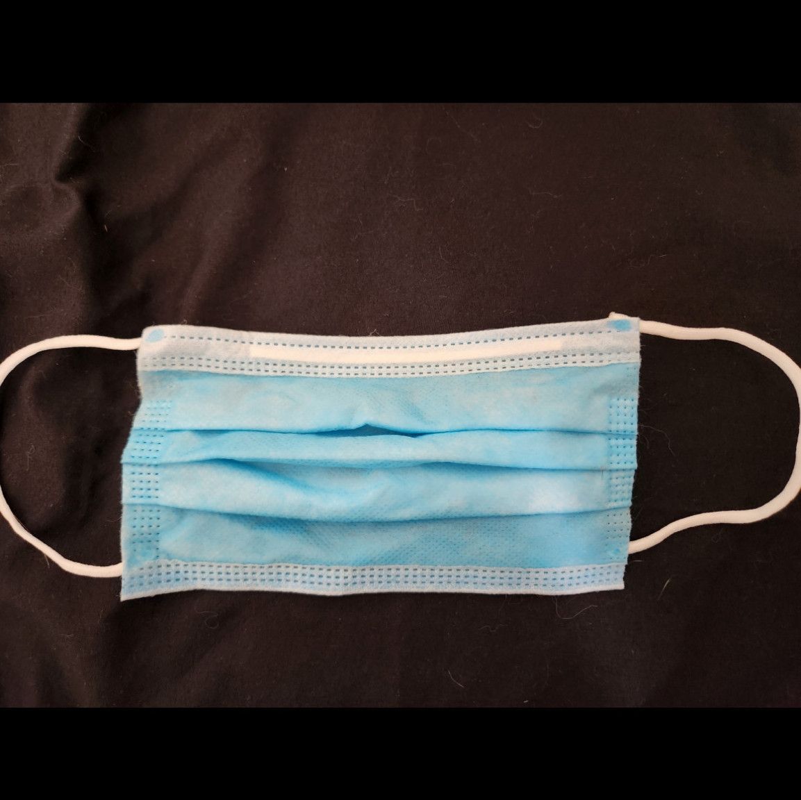 Used and worn blue surgical mask