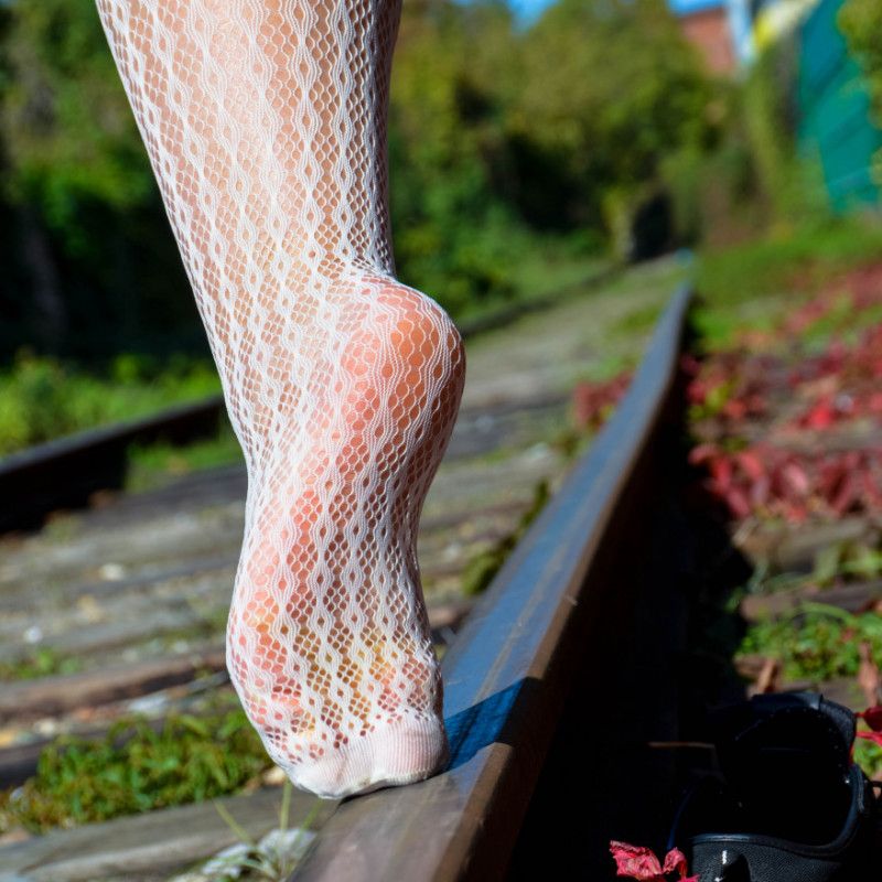 Legs in white pattern pantyhose at the railways