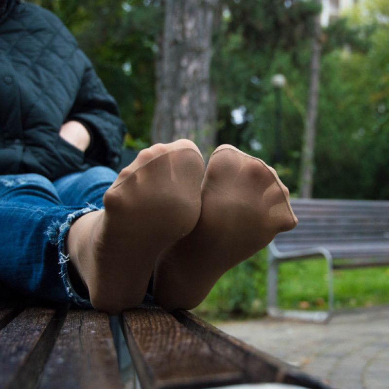 Feet in worn nylon socks with jeans