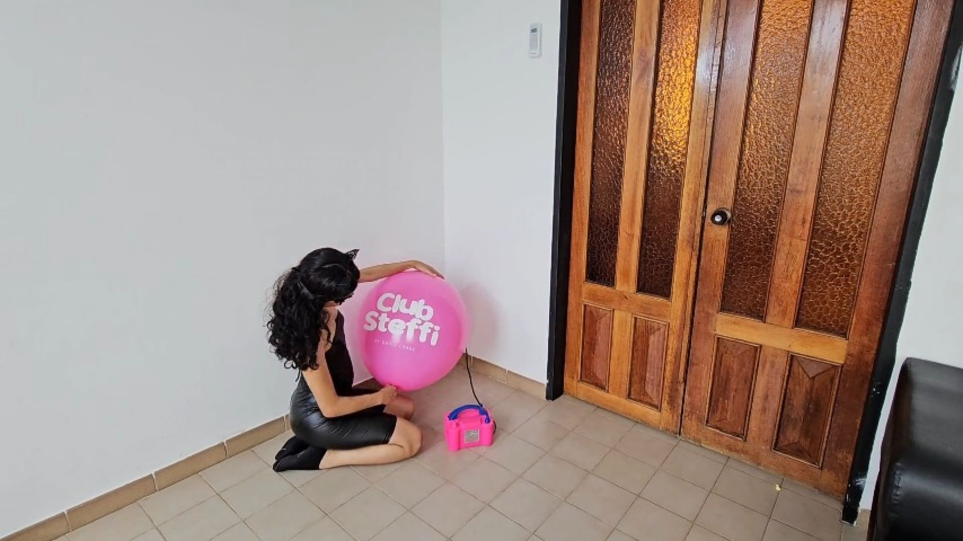 Marianna blows to burst her big pink TIFFANY balloon