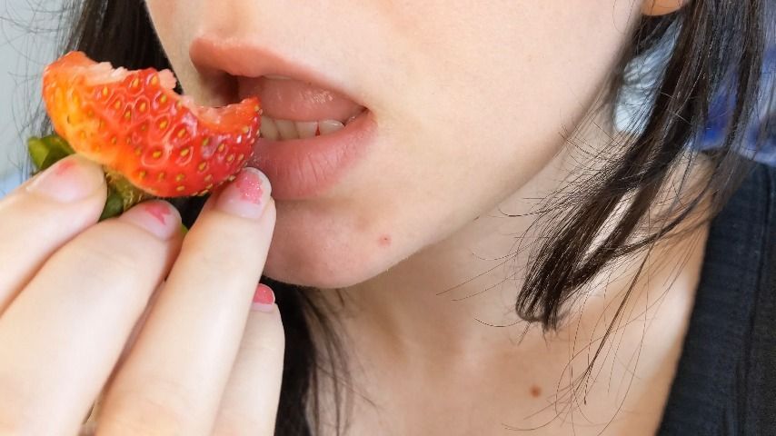 Eating a juicy strawberry close up