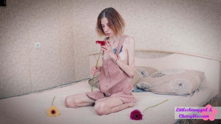 Littleskinnygirl with flowers on the bed