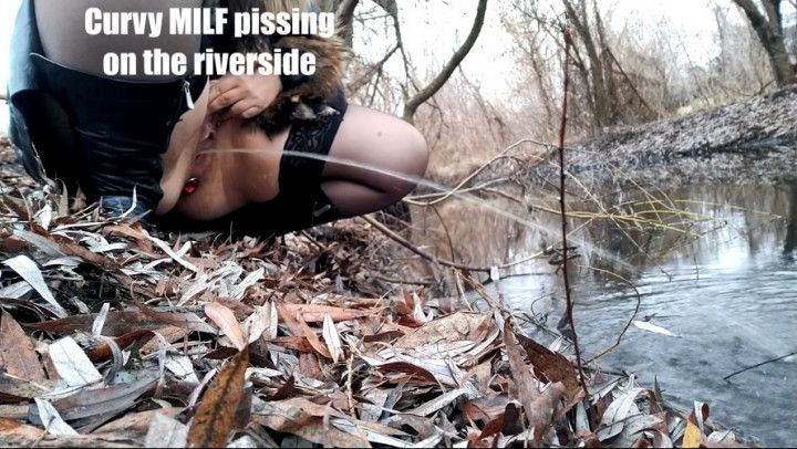 Curvy MILF pissing on the riverside