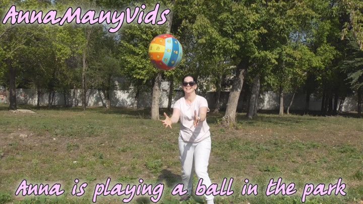 Anna is playing a ball in the park