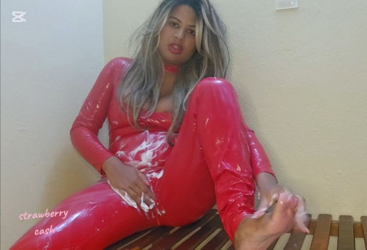 Rubbing cream lotion on Red Latex suit