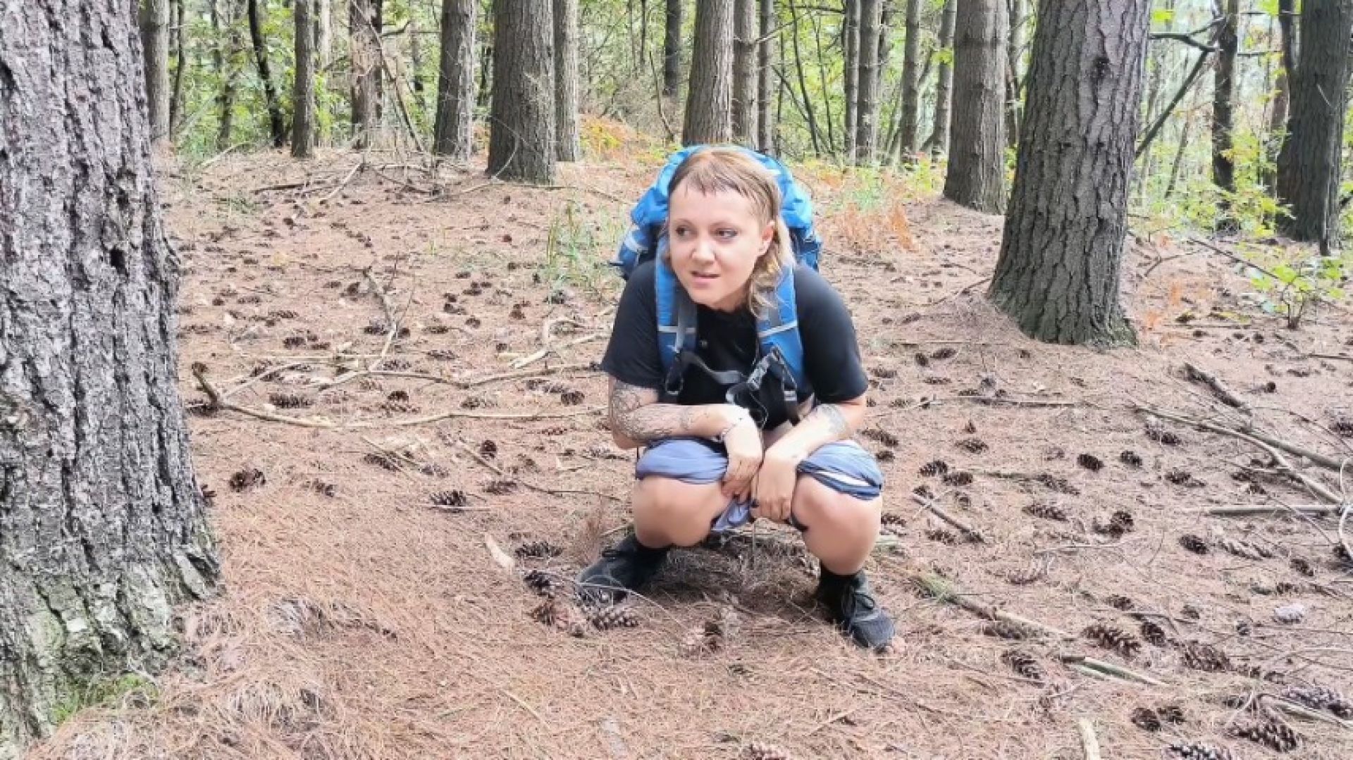 peeing in the woods with huge backpack sweaty as hell