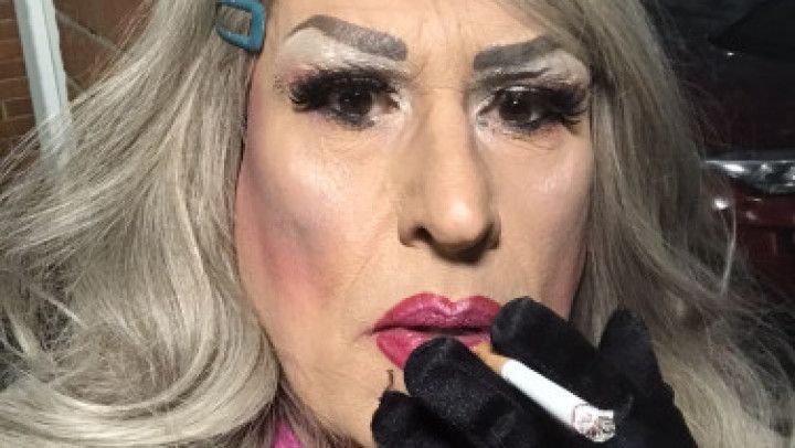 Smoking transvestite dolled up outside