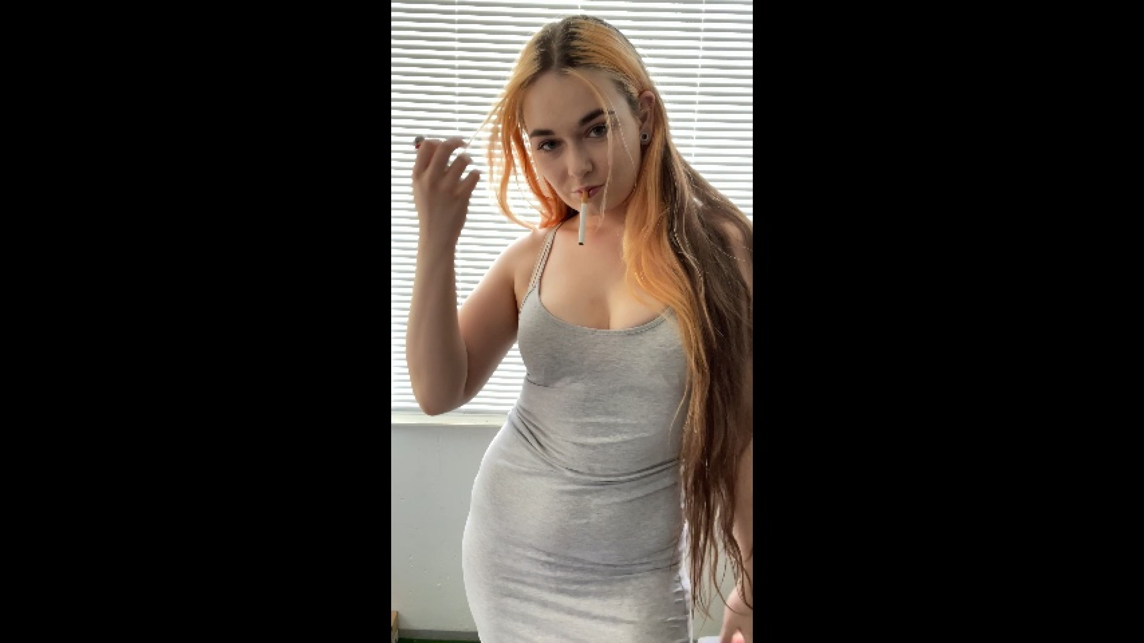 Smoking in a tight dress. Standing infront of the camera