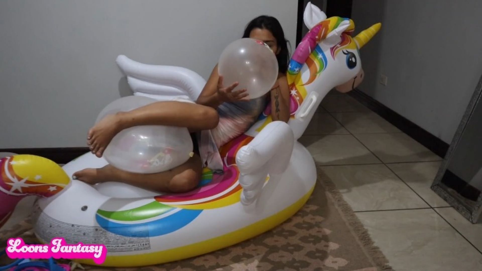 Akina blows up and pops balloons on her unicorn