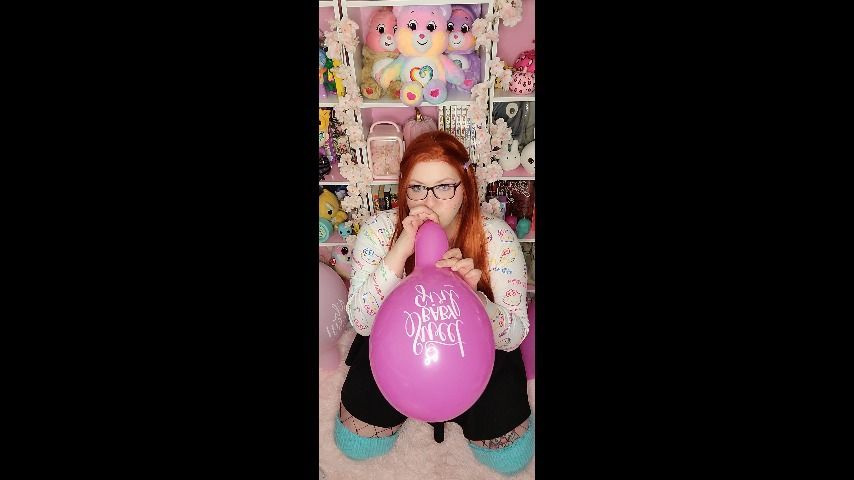 Nerdy Ginger blows pink balloons