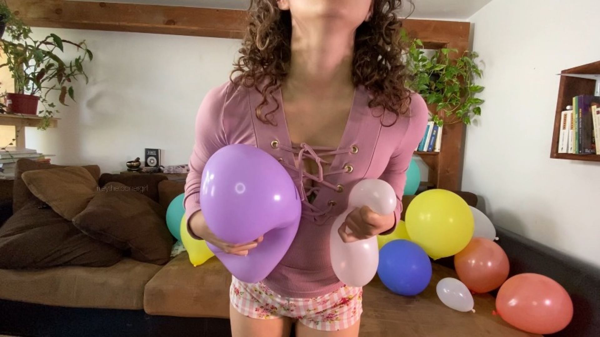 Ballons popping with hand and against breasts