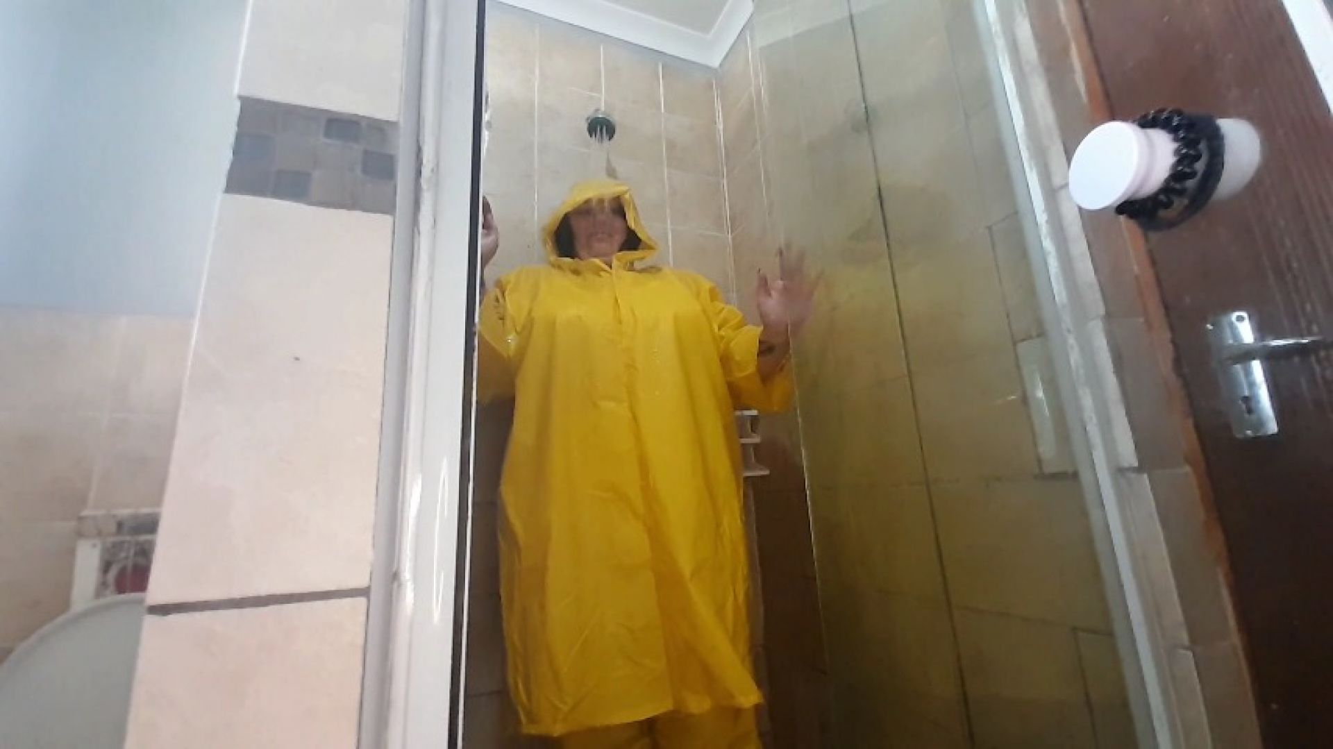 Yellow PVC rainwear wet in shower