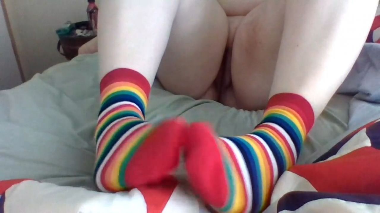 Long Rainbow Socks on an Old Iron Bed Frame