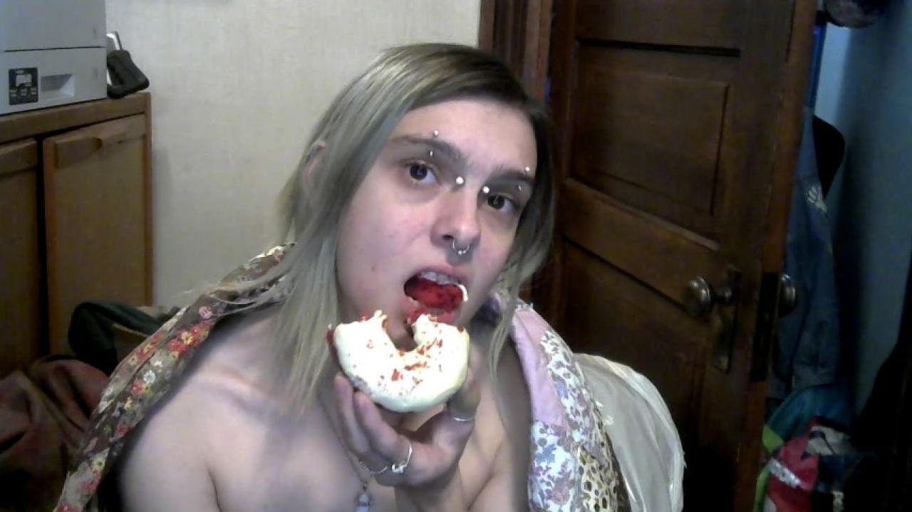 Shirtless babe in blanket seductively eats a donut