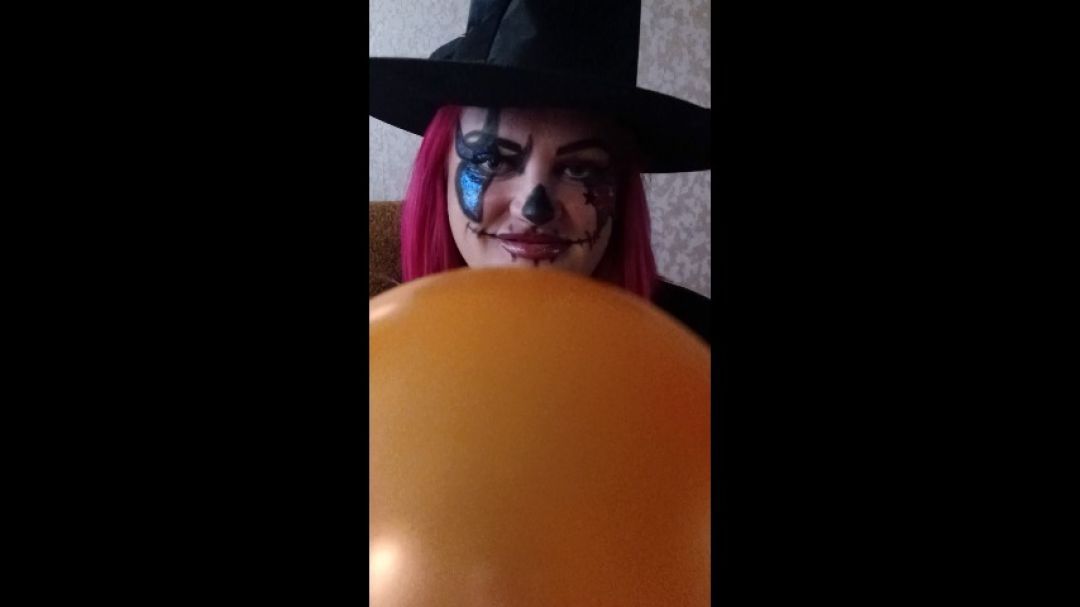 halloween girl blowing orange balloon