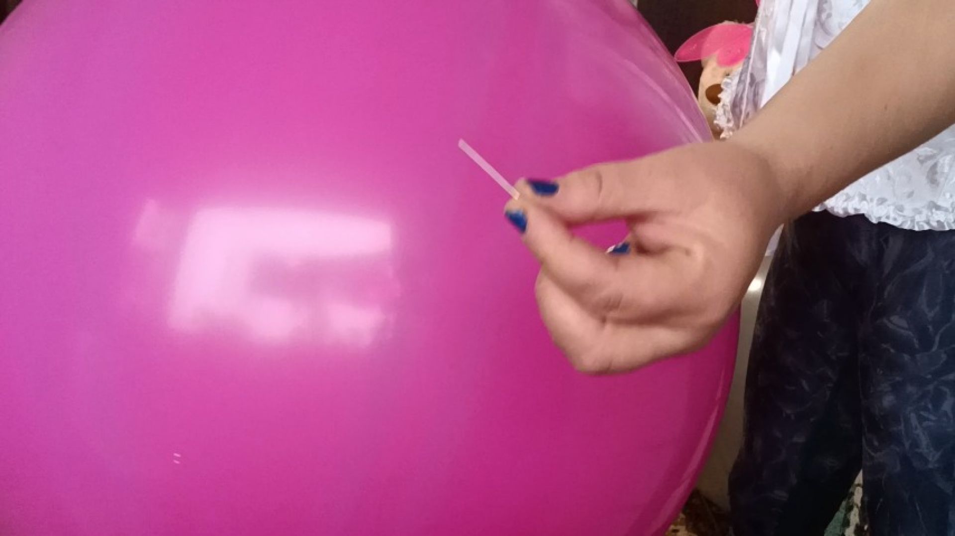 girl poping big balloons with needle