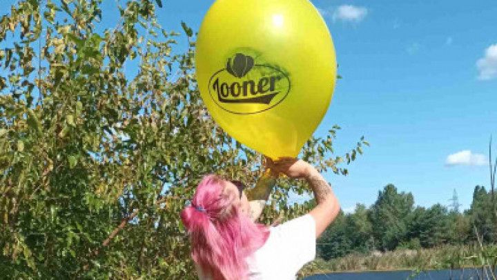 Girl blowing big yellow balloon