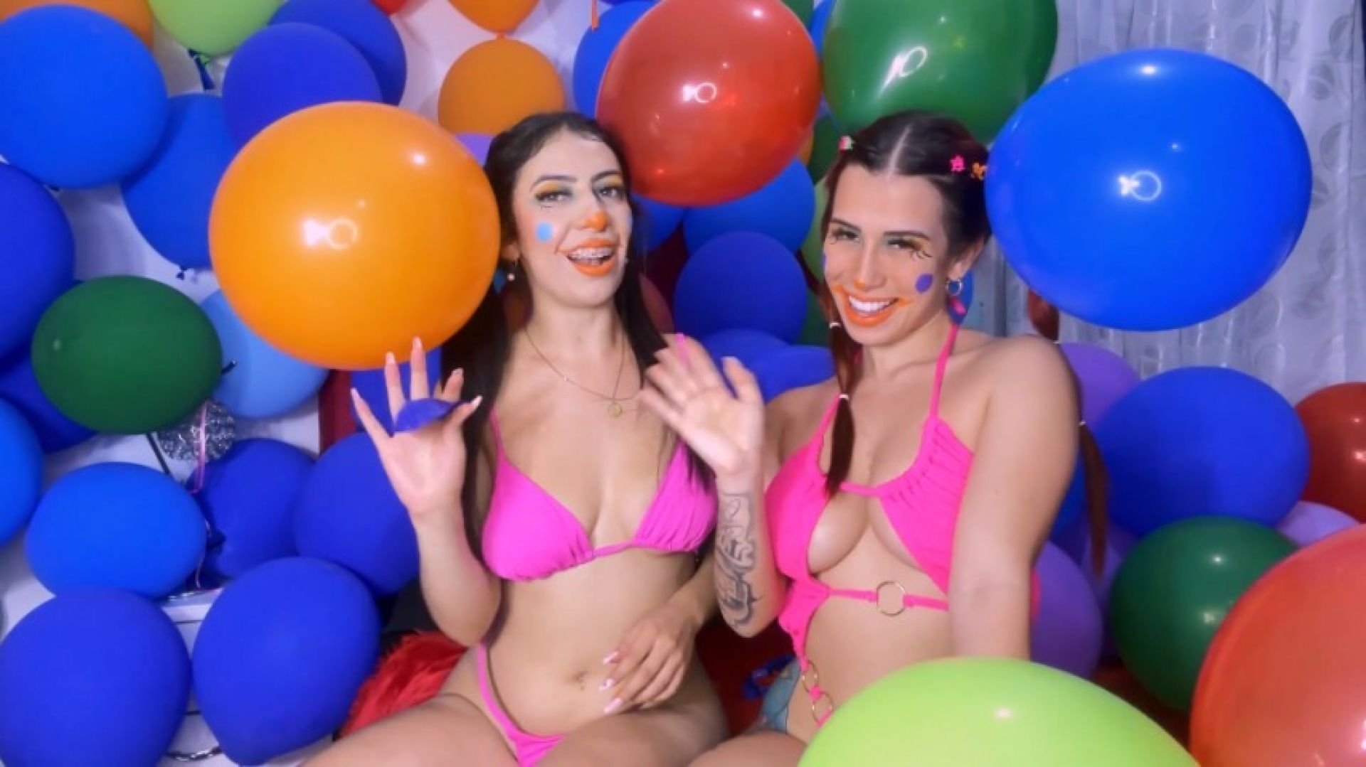 Two cute clowns inflating balloons