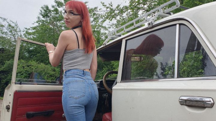 Redheaded Anya cranks an old car with a red leather interior