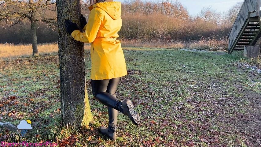 girl in yellow rubber raincoat, pants n boots public outdoor