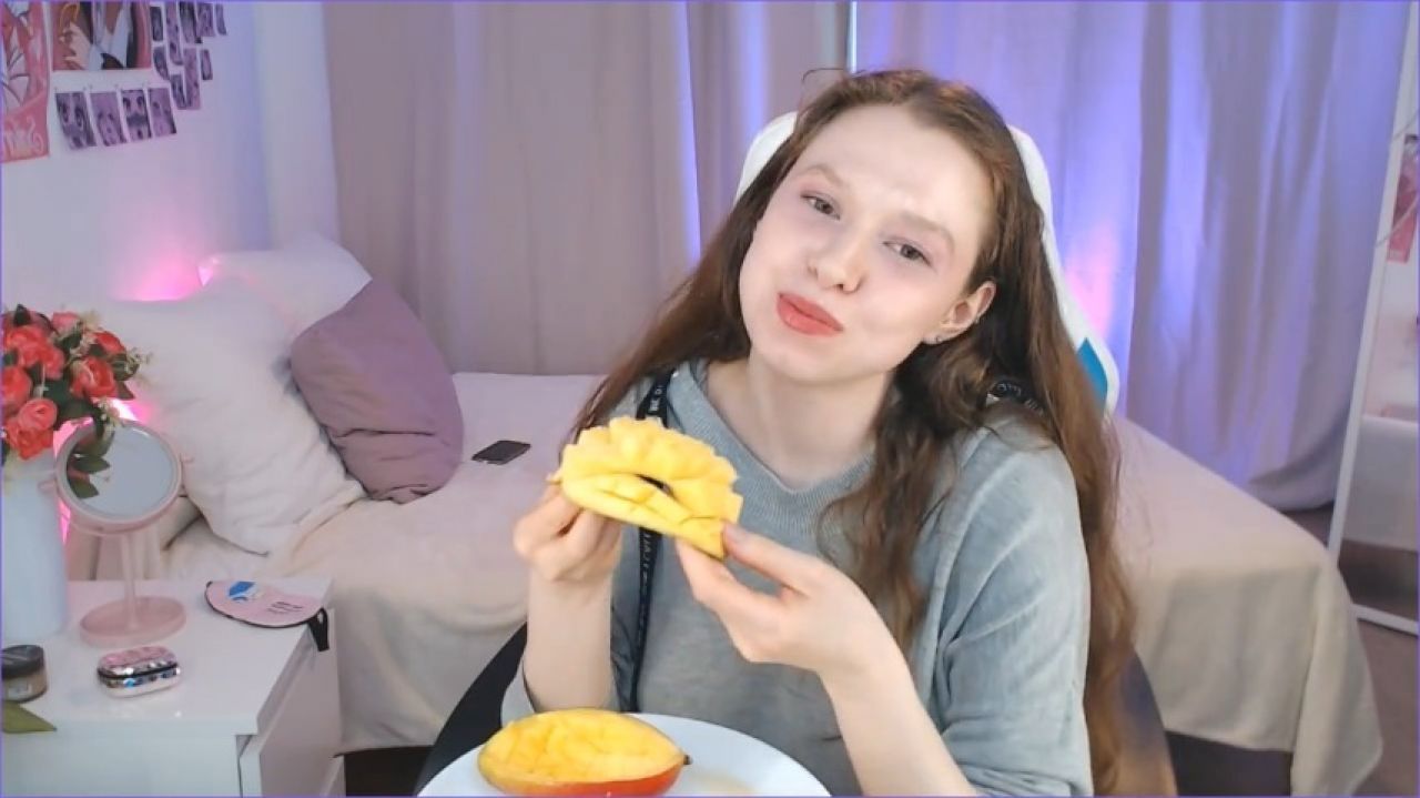 cute redhead eating juicy mango