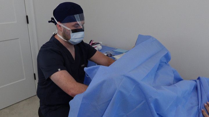 Doctor Nick wears surgical PPE and performs vaginal exam