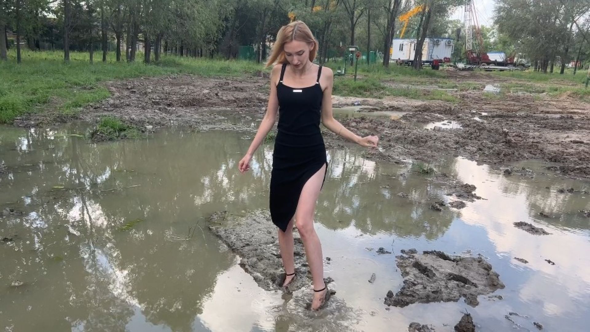 girl in high-heeled shoes walks in mud, her shoes get dirty