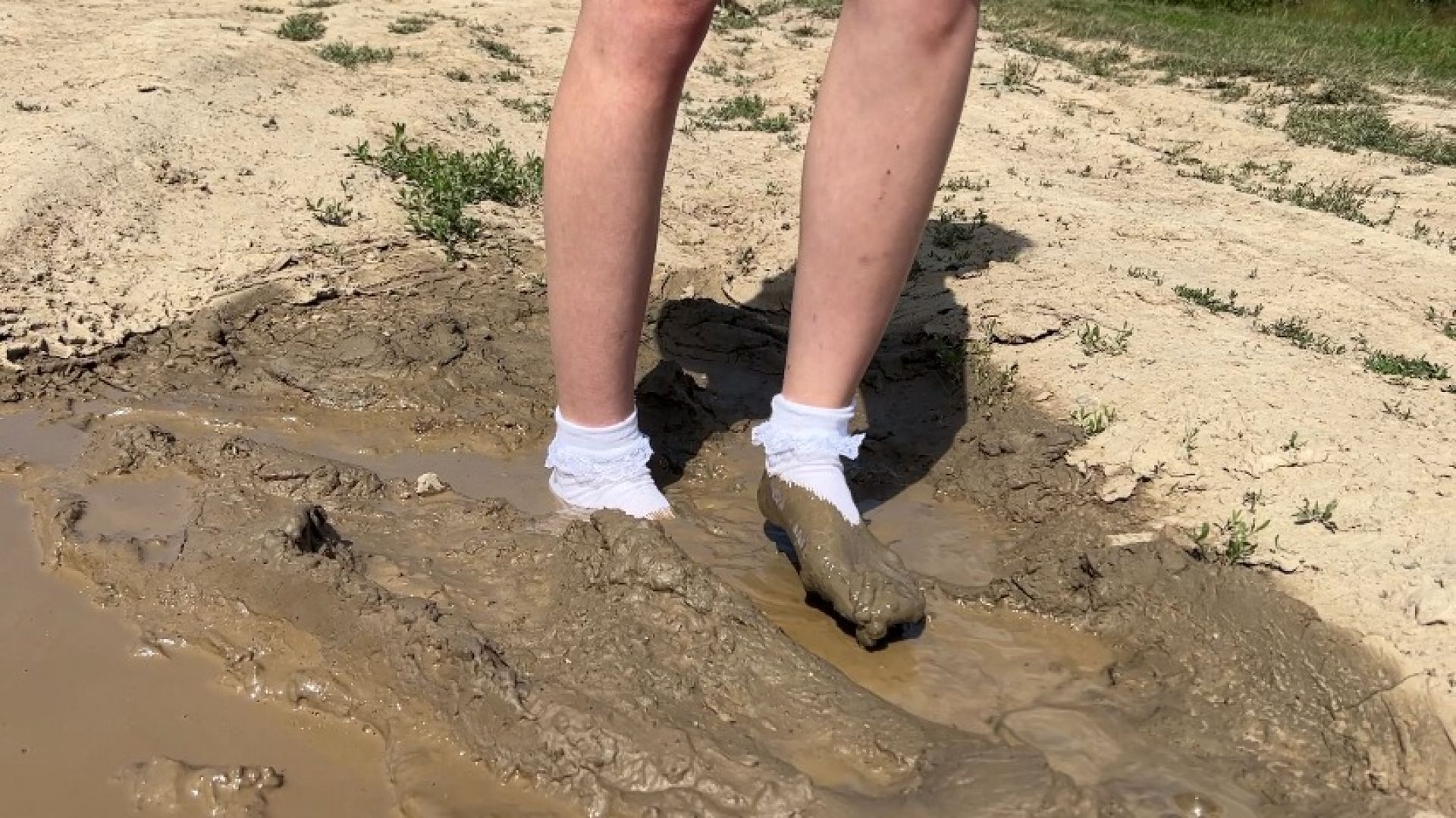 girl in high-heeled sandals soils her hite socks in mud