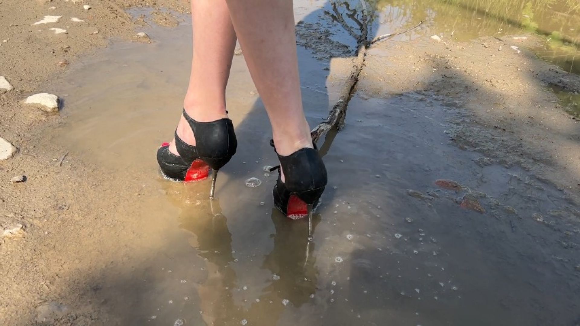 girl in high heels walks in the mud