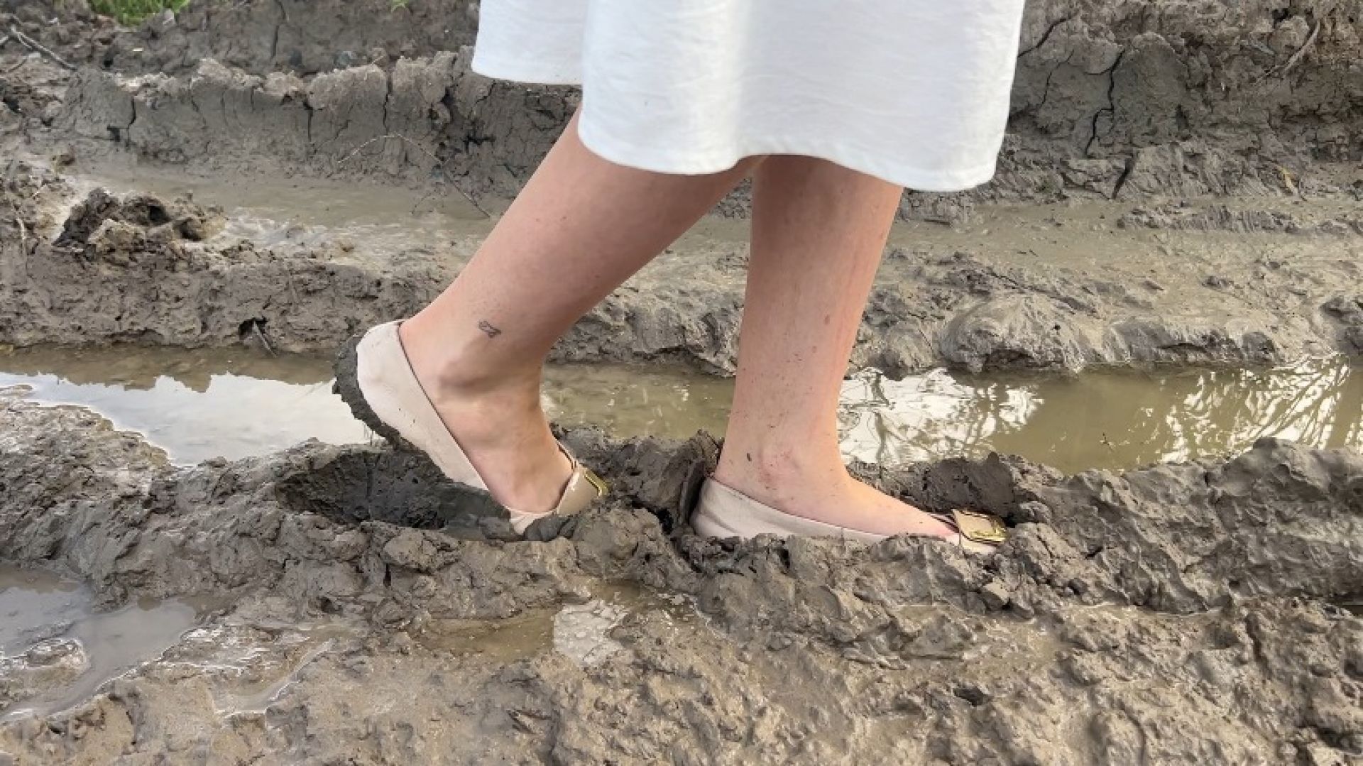 girl in ballet shoes slides through mud and make dirty shoes