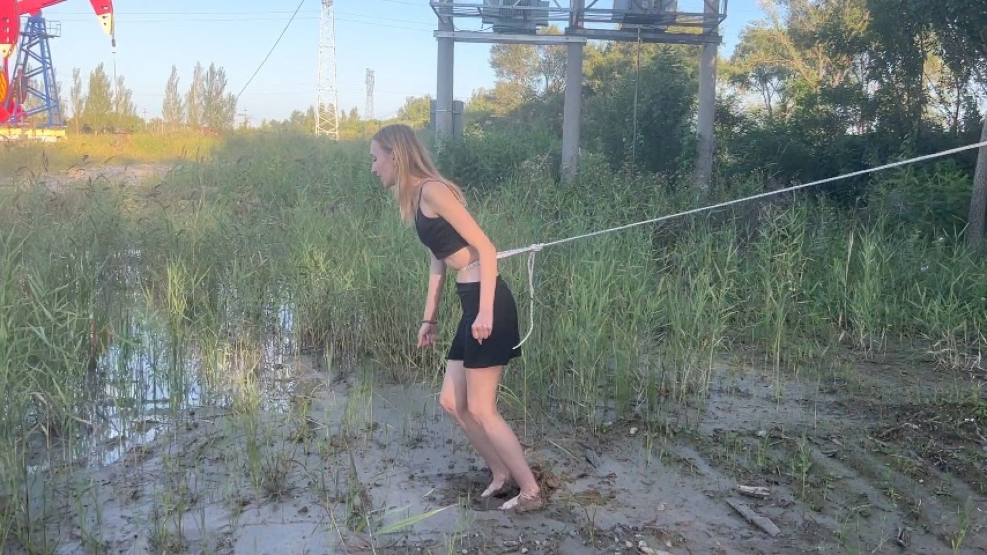 girl tied to tree slides bare feet through mud try to escape