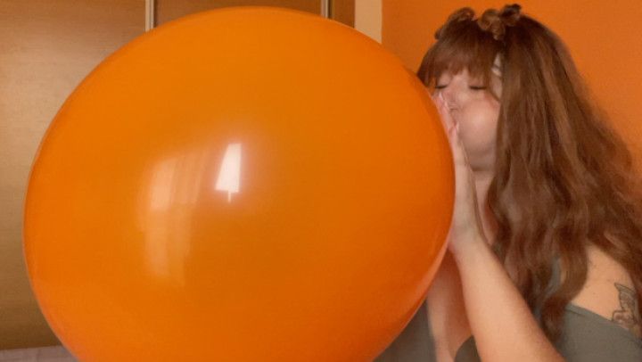 blowing up a huge orange balloon