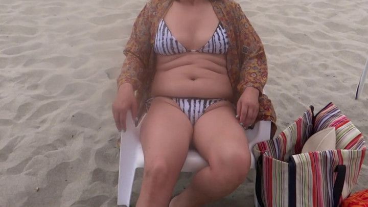 Beautiful stepmother on the beach very excited shows off and