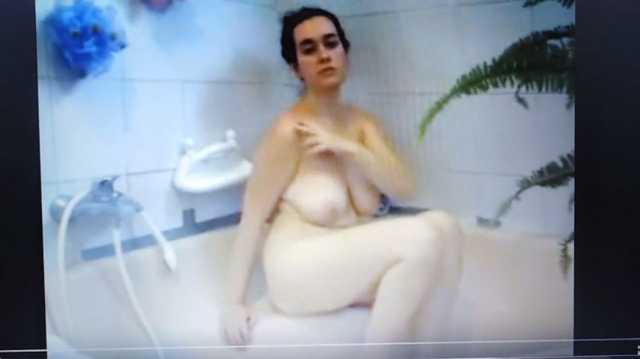 Sitting nude in the bath tube, preparing to shower