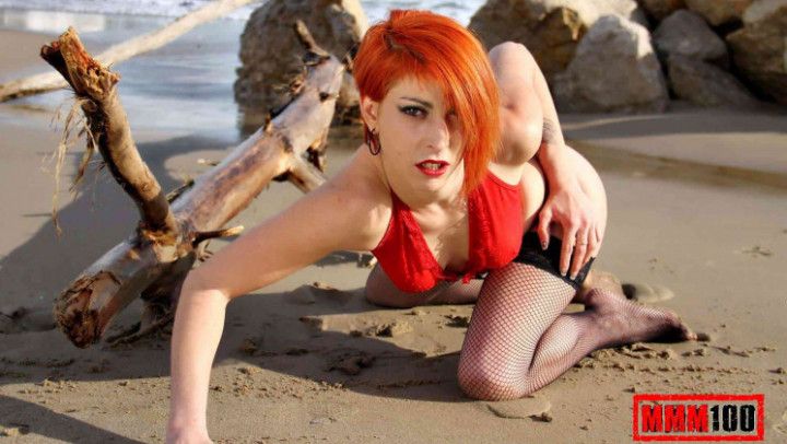 Pretty redhead Lyza Vondee doing a striptease by the beach