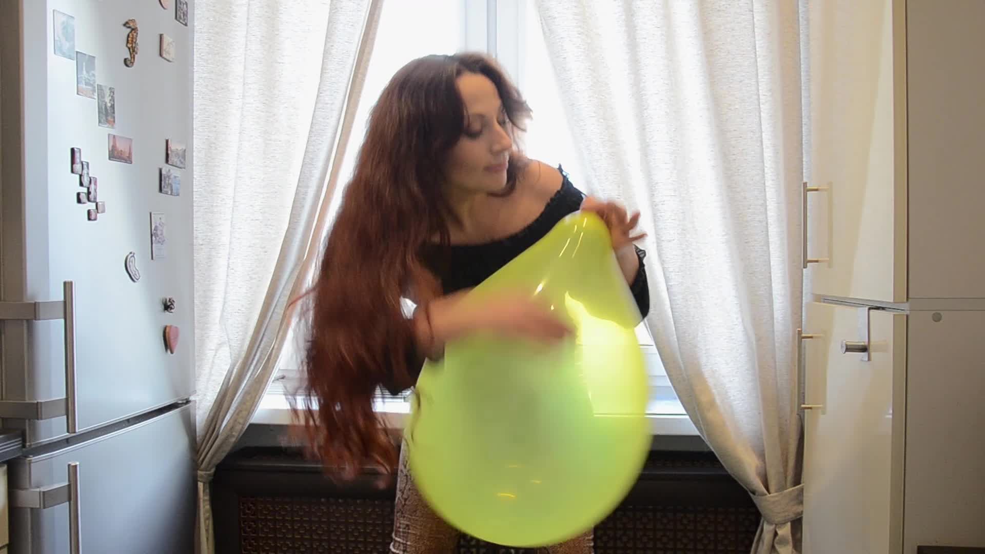 Nathalie Blows To Pop Yellow Balloon