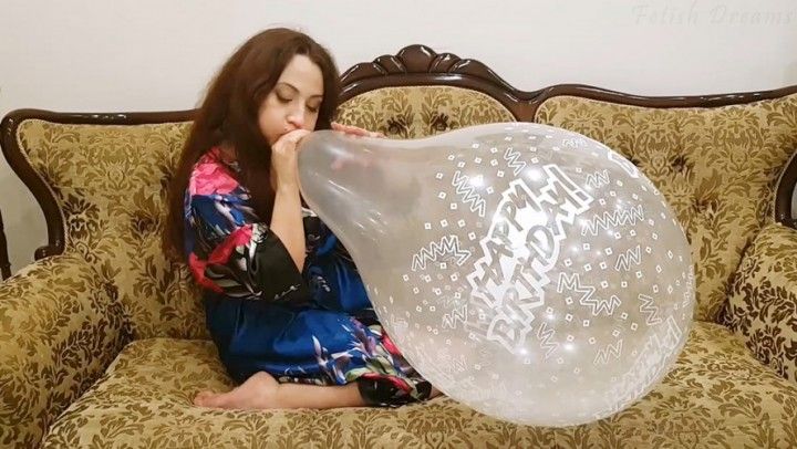 Nathalie Blows To Pop Clear Balloon