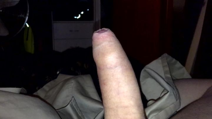 Wanking and cumming in a condom in bed