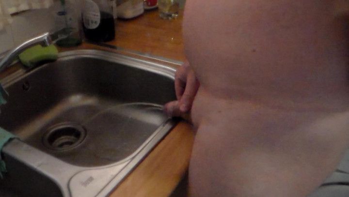 John is Peeing into the Kitchen Sink