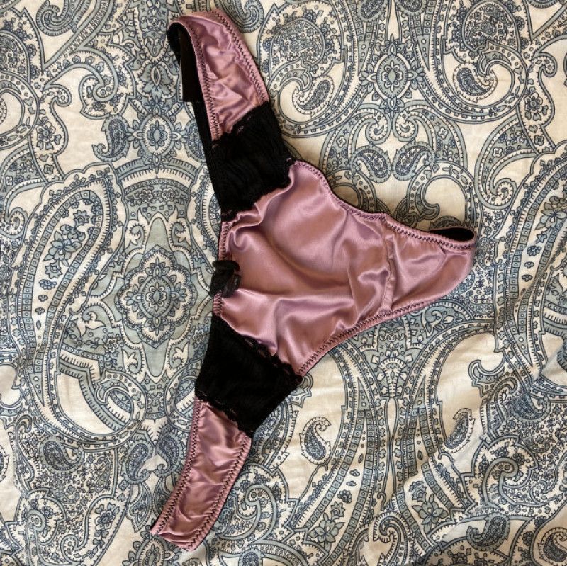 Pink and black silky thong worn