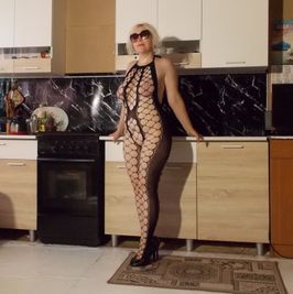 In fishnet bodystocking on kitchen