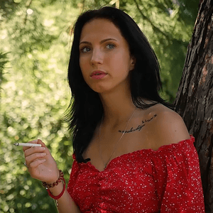 Seductive Russian beauty smoking slim cigarette outdoors