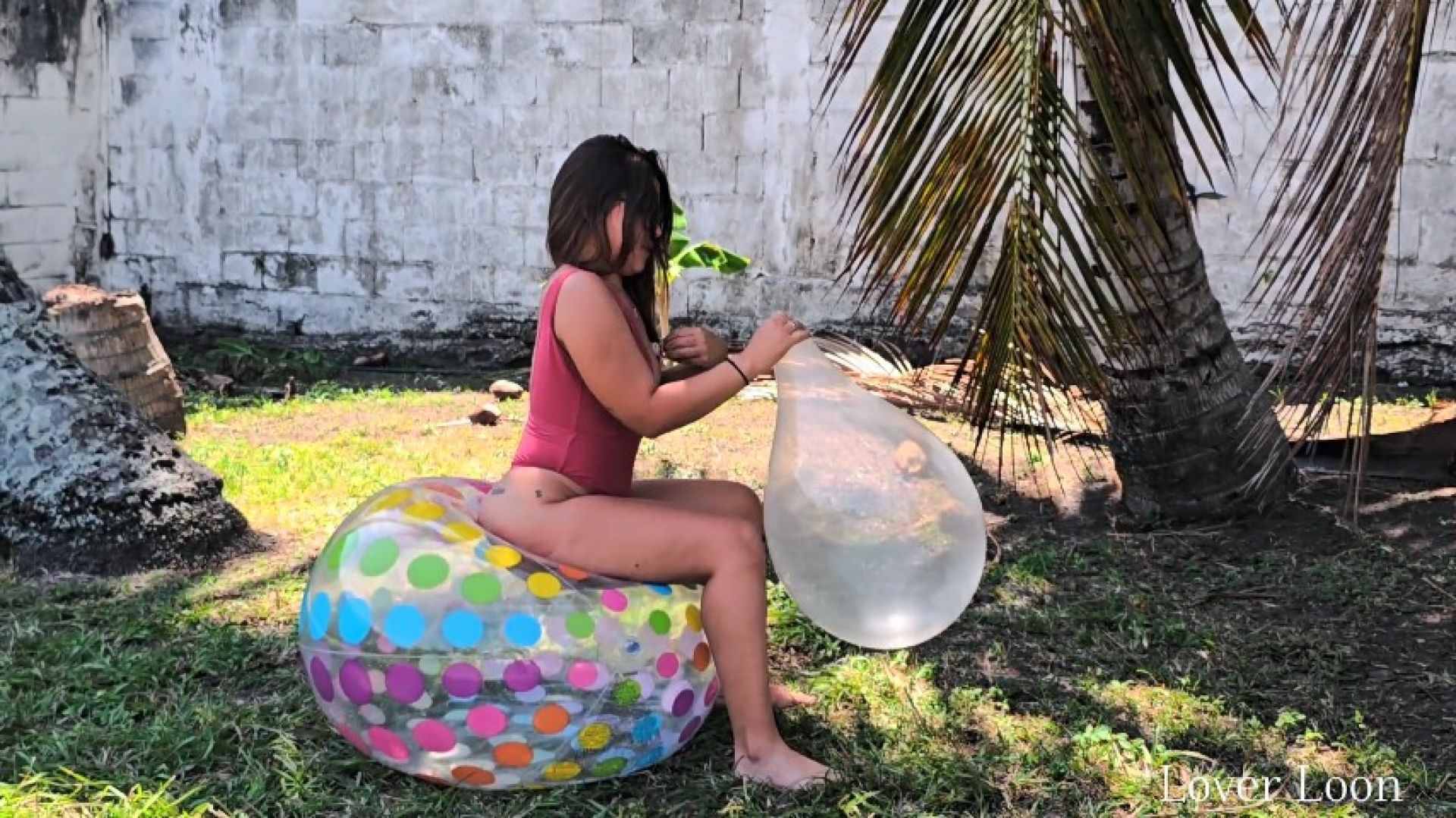 Nikki blows to explode a beach ball