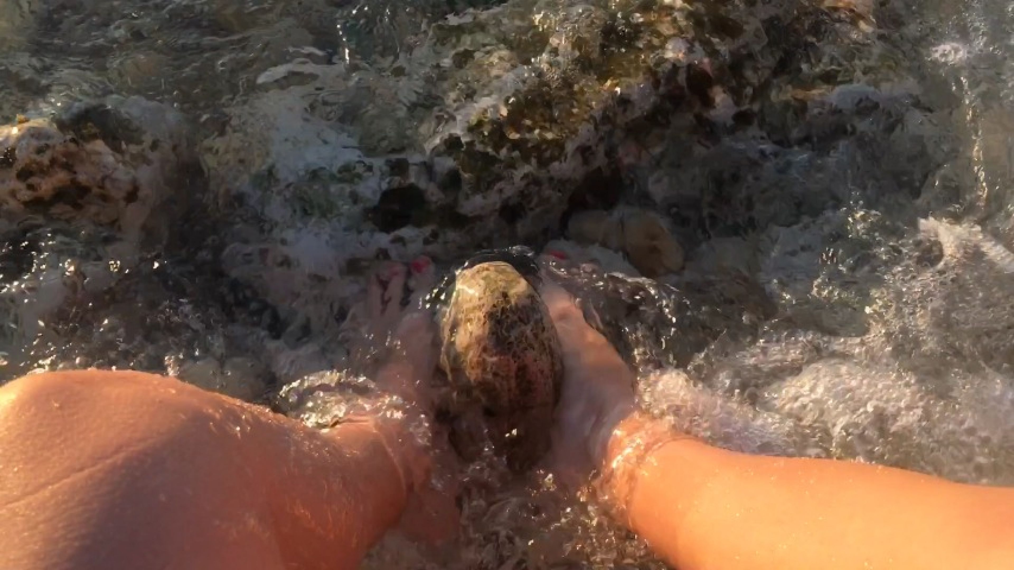 My feet in the sea over the stones
