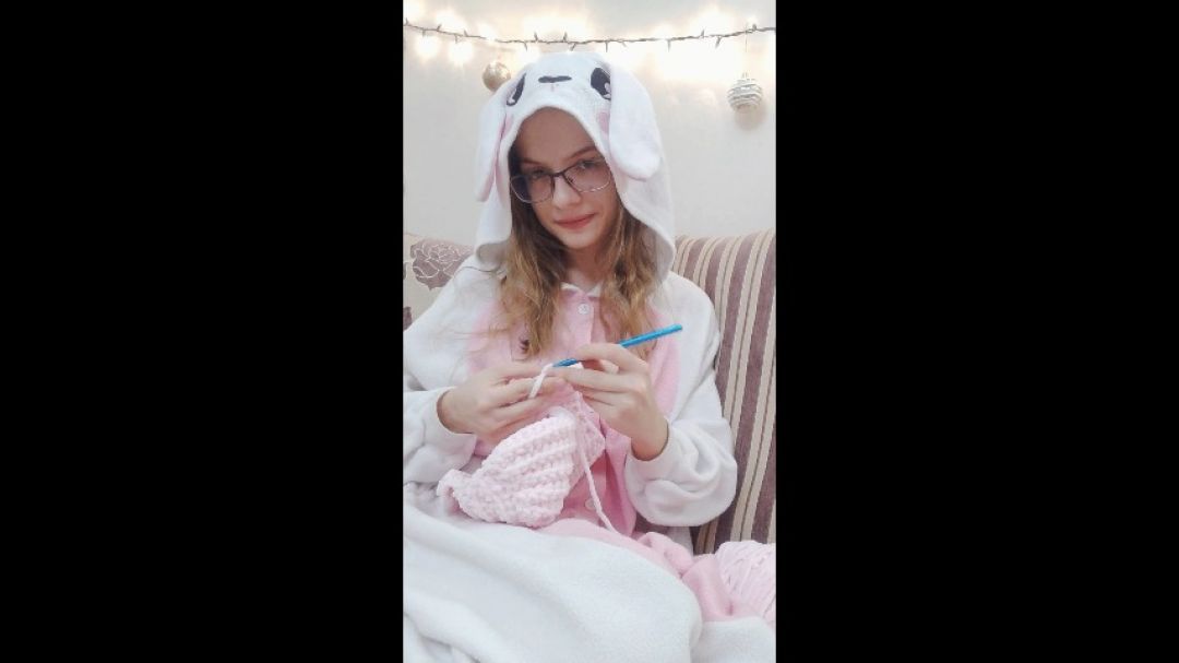 Cute bunny girl is crocheting a hat