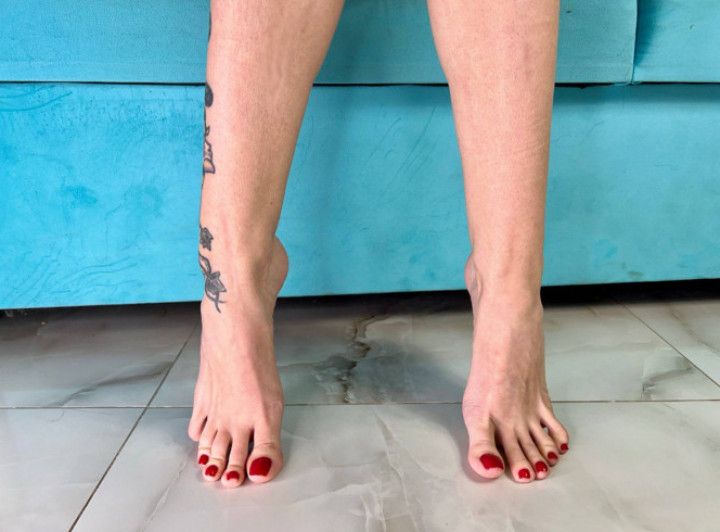 Bare feet with long toes, red toenails polish