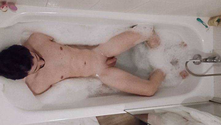 Boy takes a bath in a bathtub turning in different positions