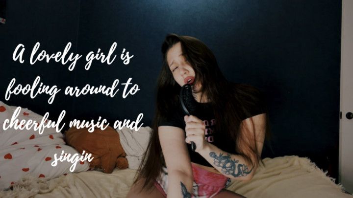 A lovely girl is fooling around to cheerful music and singin